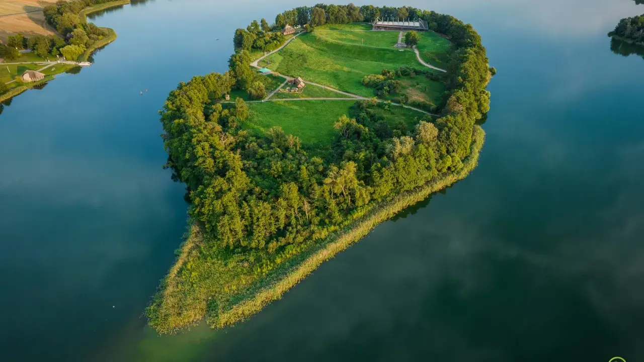Wyspa w kształcie serca z zabudowaniami i zielonymi terenami, idealne miejsce na gniezno wydarzenia kulturalne.