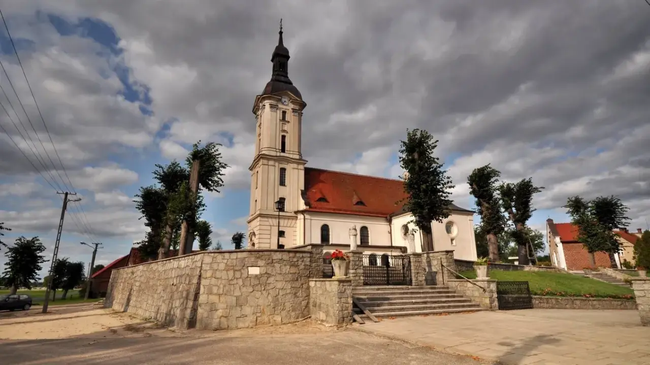 Kamienna górka duchowna z kościołem i wieżą na tle burzowych chmur.