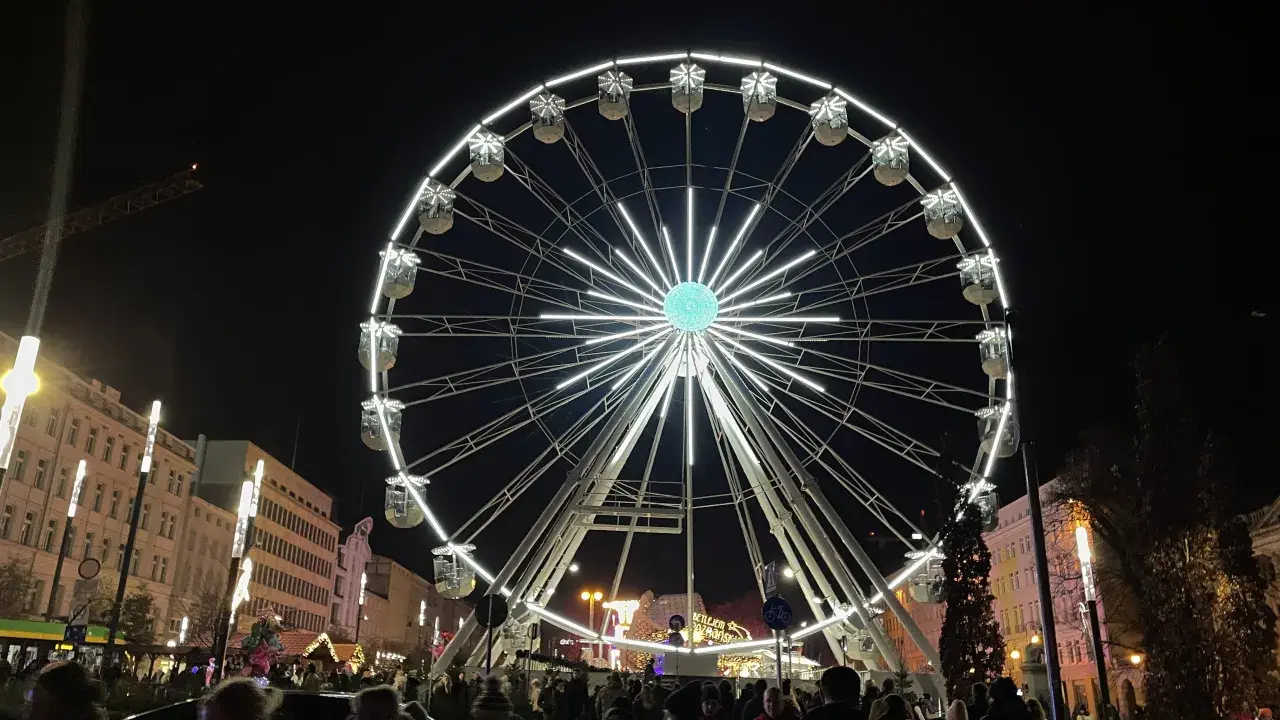 Nocny Poznań zachwyca iluminacjami. Koło widokowe na jarmarku bożonarodzeniowym w Poznaniu przyciąga tłumy.