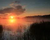 Mglisty wschód słońca nad jeziorem, idealne miejsce na weekendowy relaks.