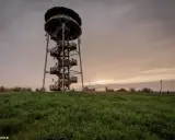 Wieża widokowa Paprotnia wznosi się nad zielonym wzgórzem, zapraszając do podziwiania zachodzącego słońca.