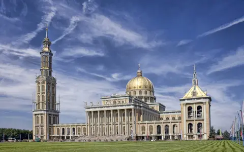 Bazylika w Licheniu, jedno z najważniejszych miejsc świętych w Polsce, z dominującą złotą kopułą i wysoką wieżą.