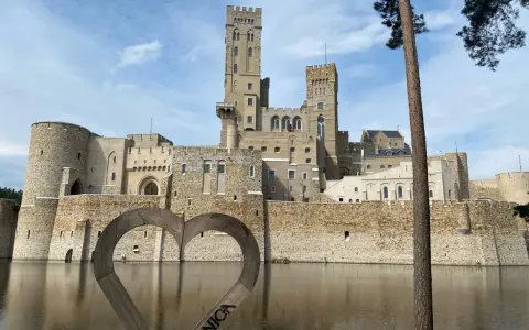 Zamek w Stobnicy, jedna z głównych atrakcji Puszczy Noteckiej, otoczony fosą. Drewniane serce z napisem "Stobnica" na pierwszym planie.