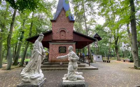 Rzeźby przed bazyliką w Licheniu: klęczący mężczyzna i Matka Boża.