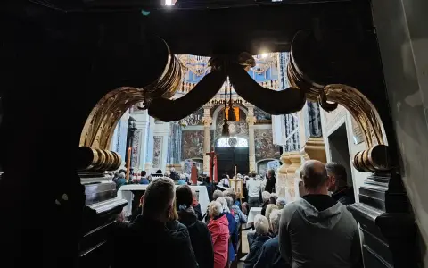 Wielkopolskie sanktuaria maryjne przyciągają wiernych. Wnętrze kościoła z ołtarzem i zgromadzonymi ludźmi.