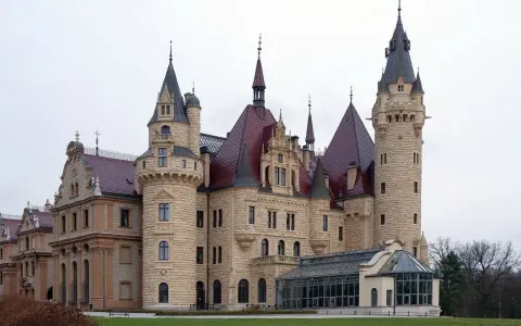 Imponujący zamek z licznymi wieżami i czerwonymi dachami. Idealne miejsce na zwiedzanie zamków i pałaców.