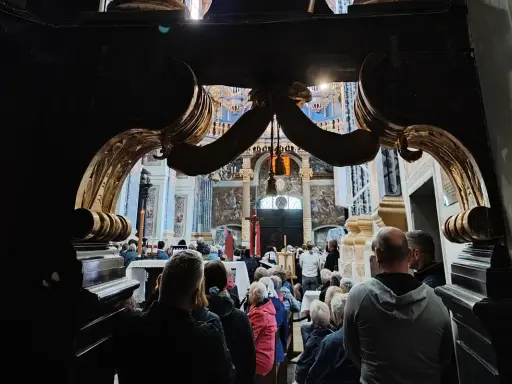 Wielkopolskie sanktuaria maryjne przyciągają wiernych. Wnętrze kościoła z ołtarzem i zgromadzonymi ludźmi.