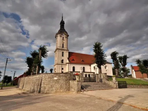 Kamienna górka duchowna z kościołem i wieżą na tle burzowych chmur.