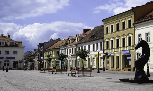 Ratusz w Koninie i okolice zapraszają na imprezy. Rynek z kamienicami i rzeźbą konia.