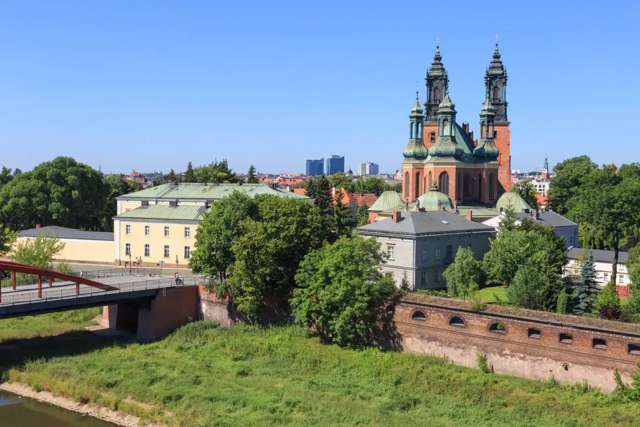 Majestatyczna katedra na Ostrowie Tumskim góruje nad zielenią i historyczną architekturą.