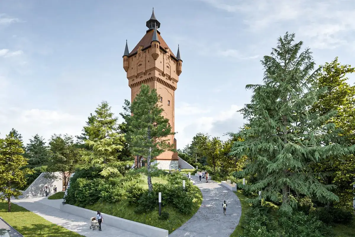 Majestatyczna wieża ciśnień w Śremie, otoczona zielenią i alejkami, gdzie spacerują ludzie.