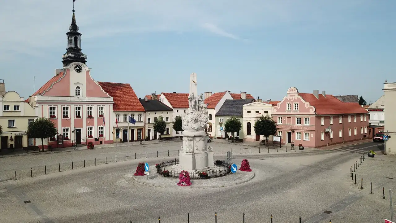 Rynek w Rydzynie z ratuszem i pomnikiem. Urokliwe kamieniczki i brukowany plac tworzą piękne rydzyna atrakcje.